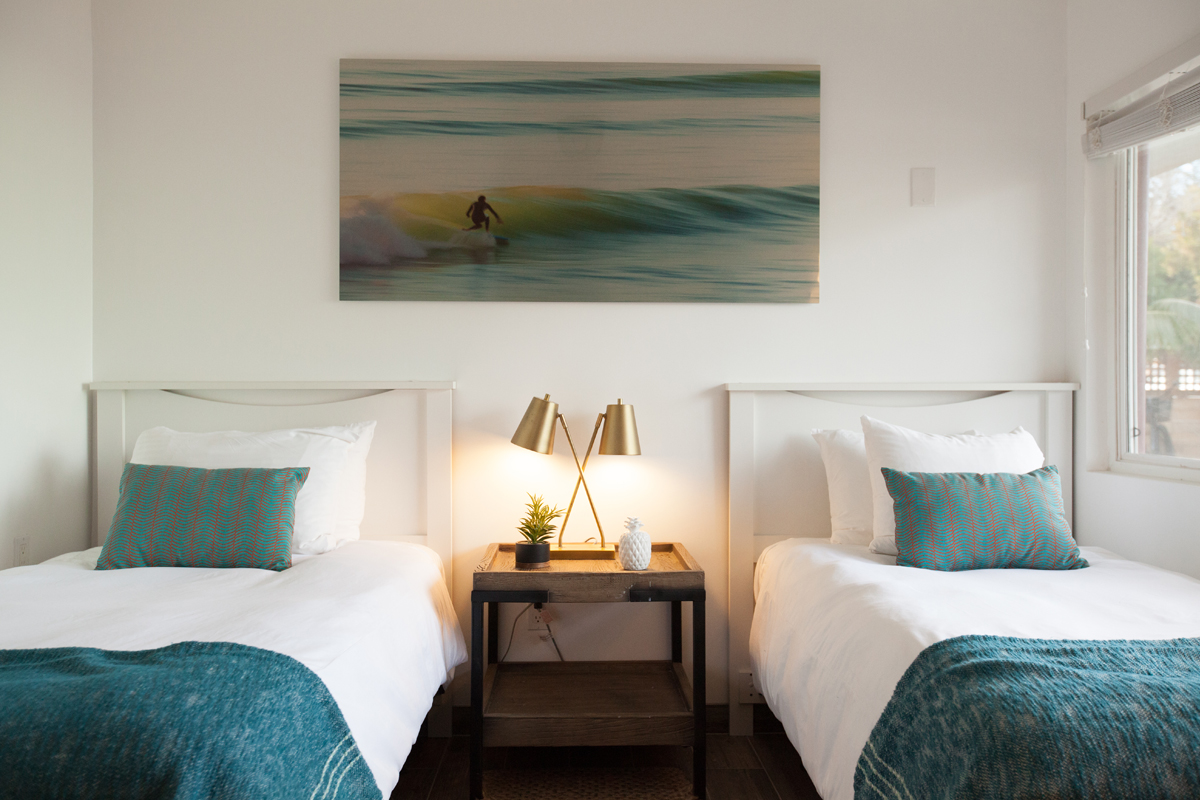 photo of 2 xl twin beds with a surf photo above the beds.